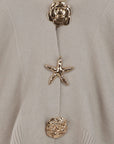 Gilet beige orné de boutons décoratifs dorés